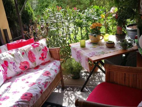 a patio with a couch and a table with flowers at Apartment in Neusäß with Barbecue and Wifi in Neusäß