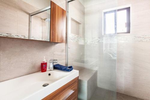 a white bathroom with a shower and a sink at Paradise Villa in Cocoyoc in Cocoyoc