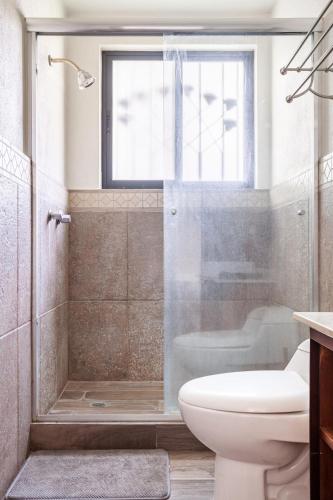 a bathroom with a shower and a toilet and a window at Paradise Villa in Cocoyoc in Cocoyoc