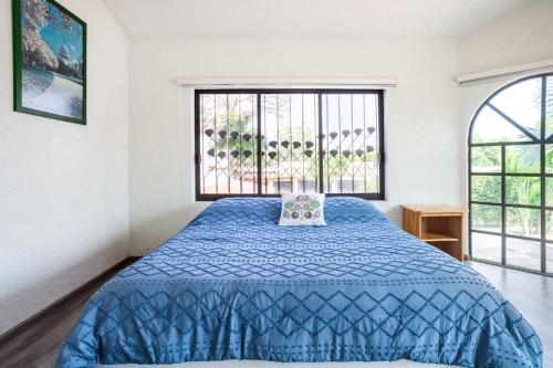 a bedroom with a blue bed and a window at Paradise Villa in Cocoyoc in Cocoyoc