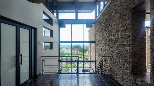 a hallway with a brick wall and a window at Self Checkin -Cozy & Stylish 2-Bedroom Apartment in Jackal Creek in Roodepoort
