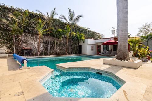 a swimming pool in a yard with palm trees at Paradise Villa in Cocoyoc in Cocoyoc
