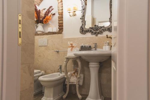 a bathroom with a sink and a toilet and a mirror at La Romantica Lolo' in Montepulciano