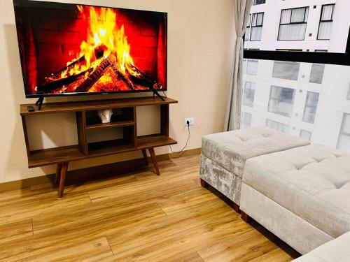 a living room with a tv with a fire on it at Amplio y céntrico departamento en el centro de Lima in Lima