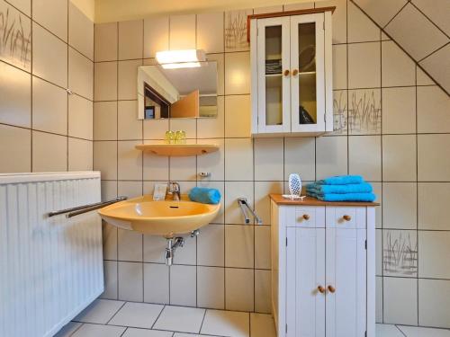 a bathroom with a sink and a mirror at Ferienwohnung Buhne 2 in Norden