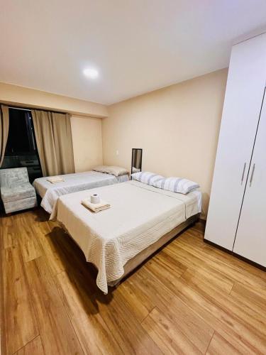 two beds in a room with wooden floors at Amplio y céntrico departamento en el centro de Lima in Lima