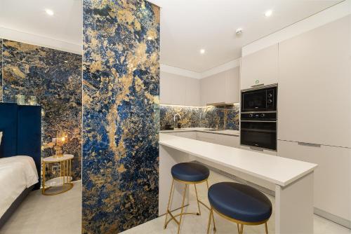 a kitchen with blue and gold wallpaper and two stools at Safira Suites 301 in Funchal