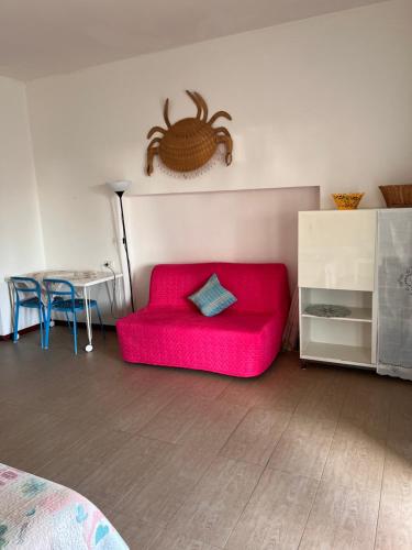 a living room with a red couch and a table at La casina di Shabbi in Vulcano