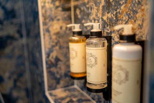 three bottles of soap on a shelf in a bathroom at Safira Suites 302 in Funchal