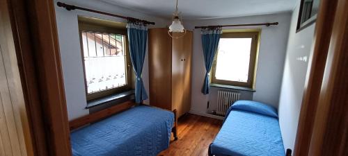 a small room with two windows and a blue couch at La Sosta1-2 in Arliod