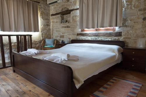 a bedroom with a large bed with white sheets at O Ilios House in Pitsidia