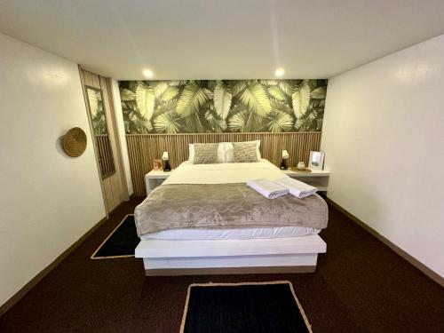 a bedroom with a large bed with a tropical wallpaper at Ope Suites calle 100 in Bogotá