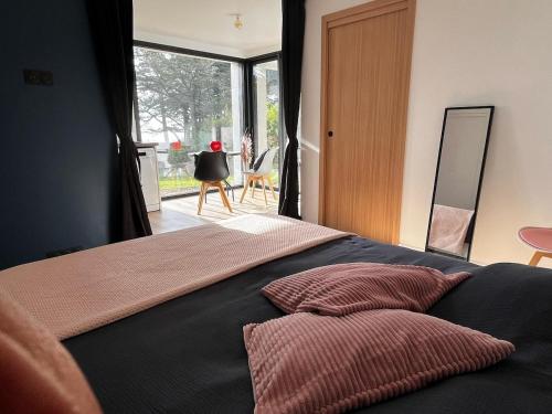 une chambre avec un lit avec deux oreillers dessus dans l'établissement Votre parenthèse enchantée dans Ty Nids d'Amour, à Névez