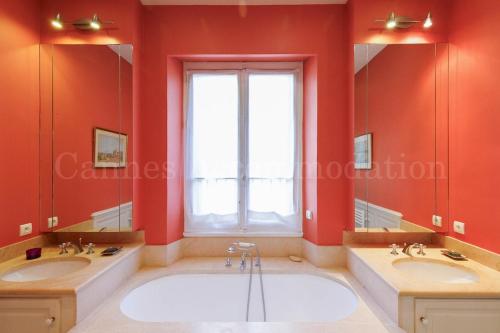 une grande salle de bains avec deux lavabos et une grande fenêtre dans l'établissement Le Clos d'Azur, à Cannes