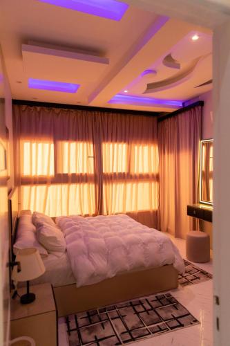 a bedroom with a large bed with purple lighting at شقة فندقية باجمل اطلاطه على البحر والنيل معا in Ras El Bar