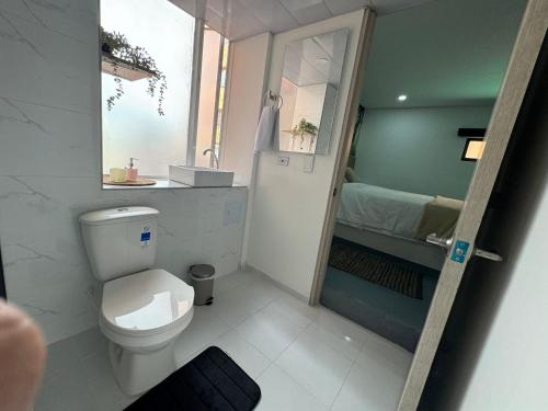 a small bathroom with a toilet and a sink at Ope Suites calle 100 in Bogotá