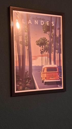 a framed picture of a car on a wall at L'airial de Laure in Ondres