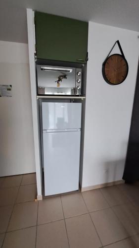 a kitchen with a stove and a refrigerator at L'airial de Laure in Ondres