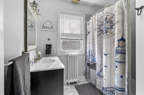 a bathroom with a sink and a shower curtain at Grove Place Beach West Haven in West Haven