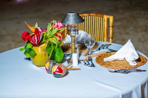 a table with a white table cloth with a vase of flowers at Jamaica Inn in Ocho Rios