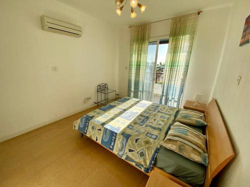 a bedroom with a bed in a room with a window at Sea Front Villa Ekaterina in Paphos City
