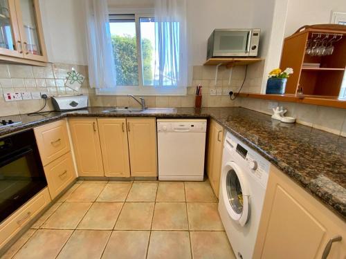 a kitchen with a sink and a washing machine at Sea Front Villa Ekaterina in Paphos City