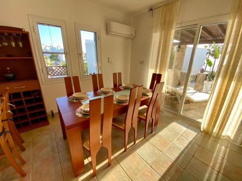 a dining room with a wooden table and chairs at Sea Front Villa Ekaterina in Paphos City