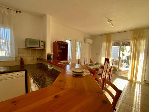 a kitchen with a wooden table and a dining room at Sea Front Villa Ekaterina in Paphos City