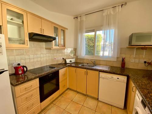 a kitchen with a sink and a stove top oven at Sea Front Villa Ekaterina in Paphos City