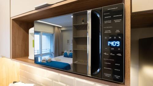 a microwave oven on a wall in a kitchen at By DH: Luxo e conforto em Perdizes, aos poucos minutos do Allianz parque in Sao Paulo