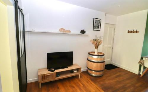 un salon avec une télévision à écran plat et un tonneau dans l'établissement Quai des Ducs, à Dijon