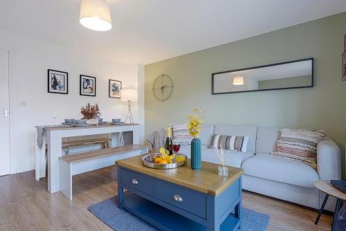 a living room with a couch and a table at Charming House - Close to Shops & City Centre - Free Parking, Self-Check-In, Fast WiFi & Smart TV with Netflix by Yoko Property in Milton Keynes