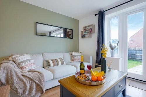 a living room with a white couch and a table with oranges at Charming House - Close to Shops & City Centre - Free Parking, Self-Check-In, Fast WiFi & Smart TV with Netflix by Yoko Property in Milton Keynes