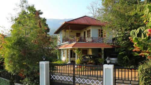 a house with a fence in front of it at Royal Mist Villa in Munnar