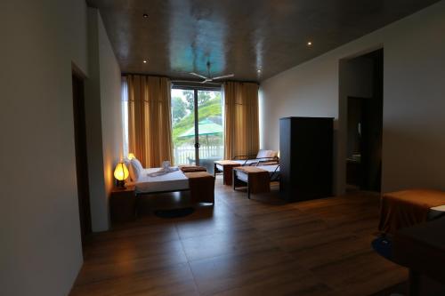 a living room with a couch and a table at Tara Waterfall in Rakwana