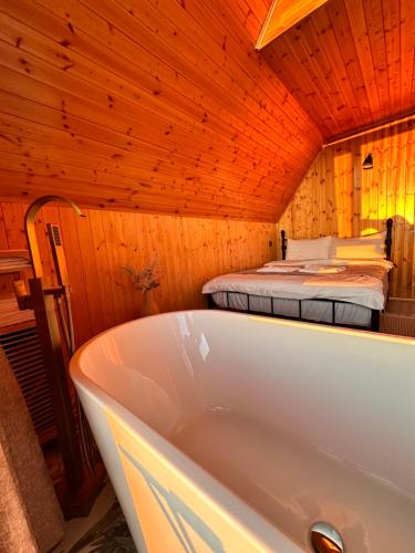 bañera en una habitación con cama en SilenT Hill Cottage, en Gant'iadi