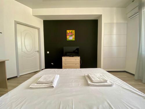 a bedroom with a large white bed with two towels at Apartament cu 2 odai Testemiteanu in Chişinău