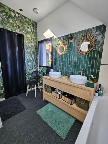 une salle de bain avec deux lavabos et un miroir dans l'établissement Votre parenthèse enchantée dans Ty Nids d'Amour, à Névez