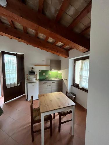 a kitchen with a wooden table in a room at Castello di Piagnano in Caprazzino