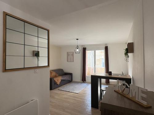 a living room with a couch and a table at Charmant studio in Courseulles-sur-Mer