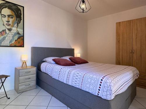 une chambre avec un lit et un tableau au mur dans l'établissement Appartement Chopin au coeur de Nancy, à Nancy