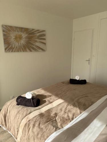 a bedroom with a bed with two towels on it at Le Colisée à deux pas in Mainvilliers