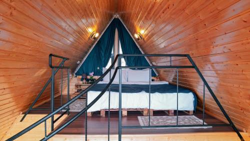 una cama en una habitación con una pared de madera en SilenT Hill Cottage, en Gant'iadi