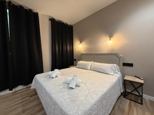 a bedroom with a bed with two towels on it at CC Opera Suites in Madrid