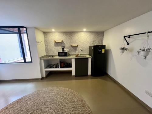 a kitchen with a counter and a refrigerator in a room at Ope Suites calle 100 in Bogotá