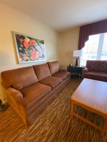 a living room with a brown couch and a table at Vacation Village in the Berkshires in Hancock