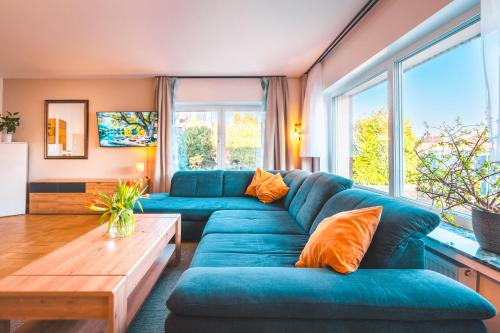 a living room with a blue couch and a table at Sleeping Home - Red House - Großes Haus für Gruppen mit 2 Wohnungen - 15 Betten - 2 Küchen - Parkplätze - Self Check-in in Bielefeld