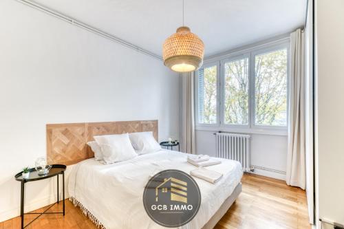 une chambre avec un lit et une grande fenêtre dans l'établissement Le Balzac - T2 Cosy proche centre ville - Stationnement gratuit, à Grenoble