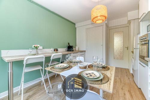 une cuisine avec une table et des chaises dans une pièce dans l'établissement Le Balzac - T2 Cosy proche centre ville - Stationnement gratuit, à Grenoble