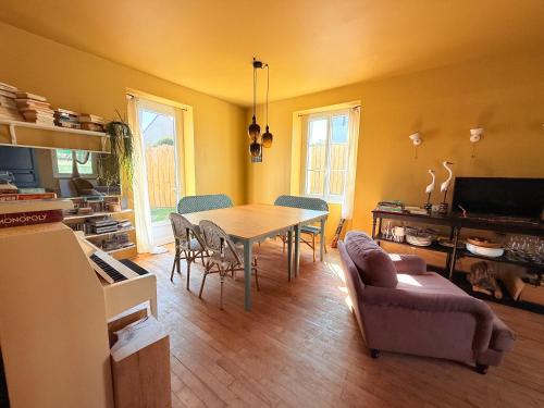 une cuisine et une salle à manger avec une table et des chaises dans l'établissement L,échappée Belle, à Dinard